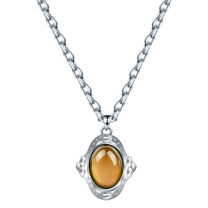 Vue détaillée d'un pendentif ovale en ambre avec une chaîne en argent de style rétro