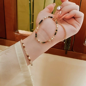 Detail of 18K gold plated pearl bracelet with colorful beads on woman wrist
