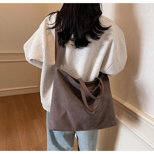Brown canvas tote bag with long straps shown in a lifestyle back view scene