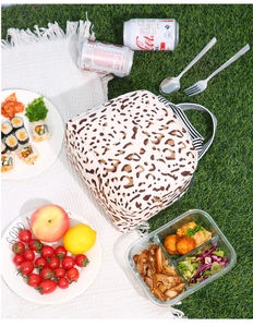 Détail du sac à lunch isotherme à imprimé léopard sur une natte de pique-nique avec repas
