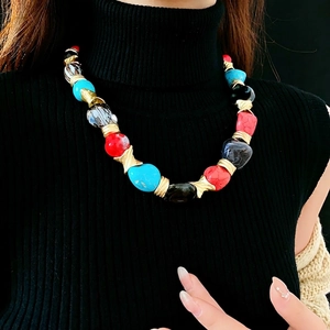 Vintage necklace with colorful chunky beads and gold geometric accents on a model