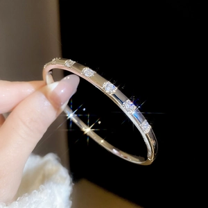 Detailed close-up of 18k gold plated bangle featuring six inlaid rectangular zircons