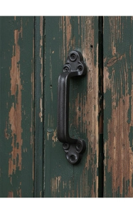 Nahaufnahme eines Türgriffs aus Gusseisen mit Hammerschlag-Finish auf altem Holzdekor