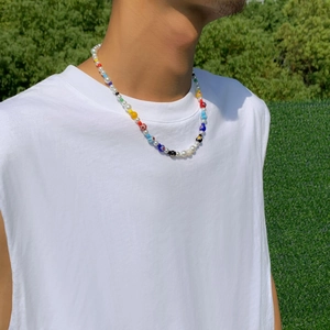 Colorful beaded flower necklace with glass beads shown on male model wearing white vest