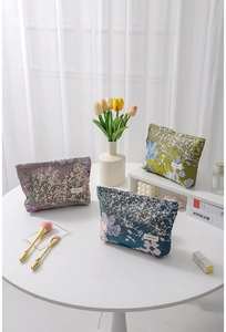 Close-up of vintage floral jacquard cosmetic bags with textured fabric and woven labels