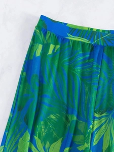 Detail of tropical palm leaf print bikini cover-up trousers in green and blue fabric