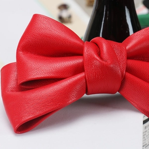 Detailed macro view of the red PU leather bow hair clip showing elegant lychee texture