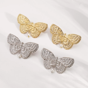 Vintage butterfly pearl drop earrings in gold and silver finish on white silk