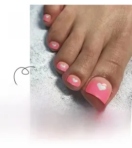 Détail macro de faux ongles de pieds dégradé rose avec motifs de cœurs blancs et pois
