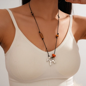 Detail of beaded necklace with horse pendant and colorful resin beads on a model