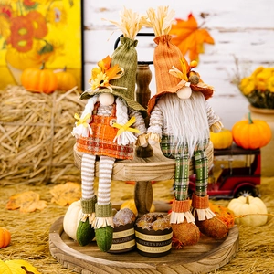 Detail of harvest gnomes in plaid outfits with maple leaf and sunflower on wood tray