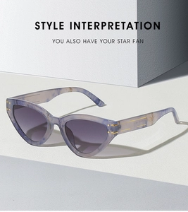 Close-up of purple marble cat eye sunglasses with gold metal hinge and grey lenses