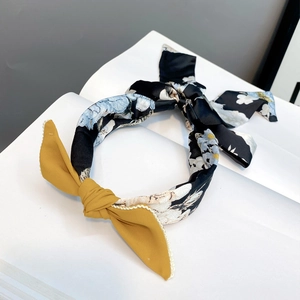 Detail of floral fabric headband with yellow ribbon bow and braided texture finish