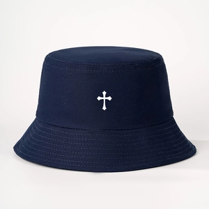 Macro detail of navy cotton twill bucket hat with minimalist white cross embroidery