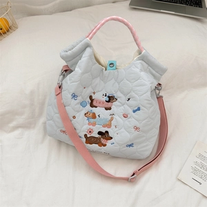Detail of embroidered dachshunds on a light blue quilted tote with pink straps