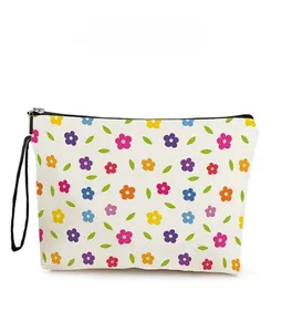 Detail view of colorful floral pattern on canvas makeup bag with black zipper and wristlet