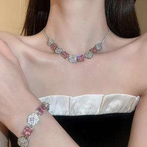 Detailed close-up of a zircon flower necklace and bracelet set with pink square gems