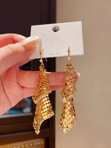 Detailed macro view of 18k gold plated tassel earrings with sparkling cubic zirconia accents