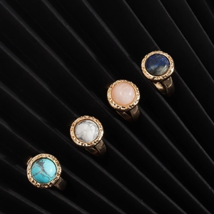 Detailed view of four vintage gold rings with colorful round natural stone inlays
