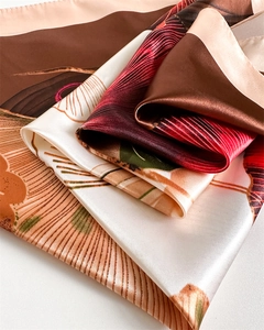 Macro shot of ginkgo print satin silk scarf showing soft folds and elegant drape