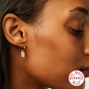 S925 sterling silver gold hoop earrings with star embossed rectangular charms worn by model