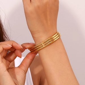 Detailed close-up of a triple-layered polished 18K gold-plated stainless steel cuff bracelet