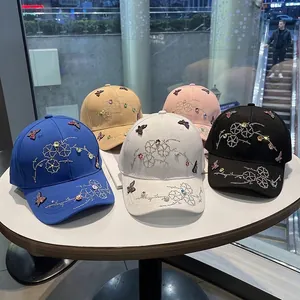 Five assorted colors of rhinestone butterfly baseball caps on display for women