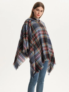Detail of hooded plaid poncho featuring blue and red tartan patterns with soft fringe edges