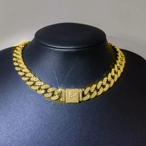 Gros plan d'une chaîne cubaine dorée 12mm sertie de strass sur buste d'exposition