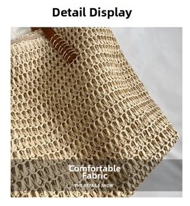 Detail view of woven straw texture and brown leather handle with contrast white stitching