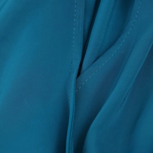 Détail de la texture satinée bleu canard et des coutures précises sur la robe midi
