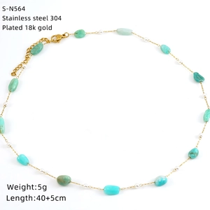 Macro detail of 18K gold plated stainless steel necklace with green stone beads and pearls