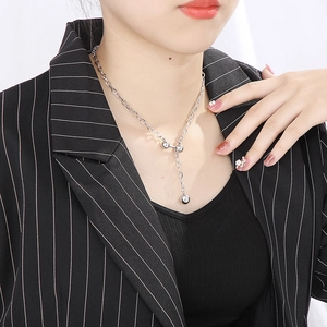 Collier en Y en acier inoxydable argenté avec pendentif perle porté par une femme