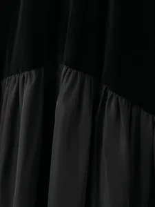Détail de la robe noire montrant la texture velours et le raccord en mousseline plissée