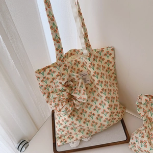 Detail of floral canvas tote bag with orange flower patterns and matching scrunchie charm