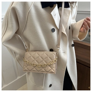 Detail view of a beige quilted crossbody bag featuring elegant gold chain and PU leather
