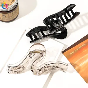 Close-up of S-shaped wave hair claws in glossy black and transparent colors with metal spring