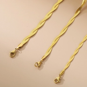 Detailed view of three golden snake bone necklaces with secure lobster clasps and braided links