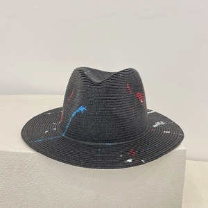 Detail of artistic red, blue and white graffiti paint on a black straw panama hat