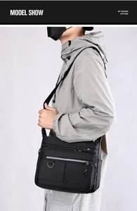 Detail of black crossbody bag showing multiple zipper pockets and durable texture