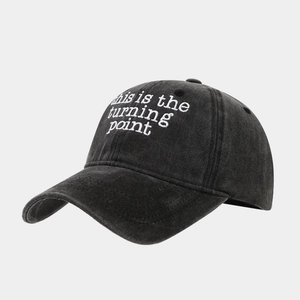 Detail of white embroidery text on washed cotton baseball cap with vintage finish