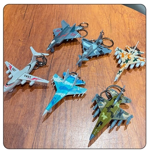 Detailed flat lay of colorful military aircraft model keychains on a wooden surface