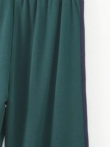 Vue détaillée du pantalon de jogging vert foncé avec taille élastique et bande latérale
