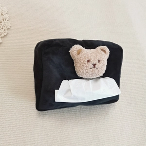Detail of black plush bear tissue box holder with cute teddy ornament on beige rug