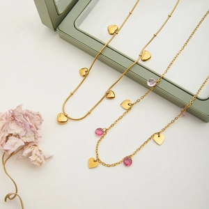 Detailed shot of 18K gold-plated heart necklaces with pink crystal and snake chain