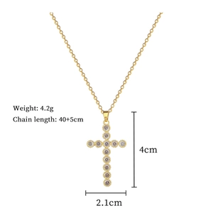 Macro detail of gold cross necklace showing dimensions 4cm x 2.1cm and 4.2g weight