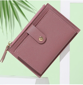 Dettaglio di un portafoglio minimalista rosa antico con fessure per carte e tasca con zip