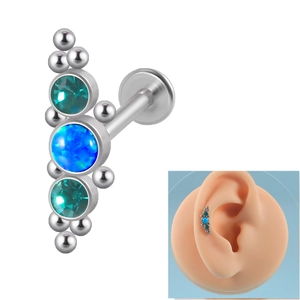 Detailed view of 16G curved labret with blue opal and teal gems on ear model