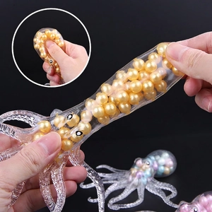 Stretchy octopus stress toy with golden beads inside shown being pulled by hands