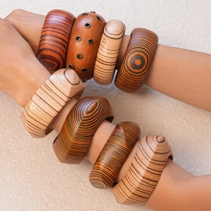 Macro shot of geometric wooden bangles with visible wood grain worn by a model